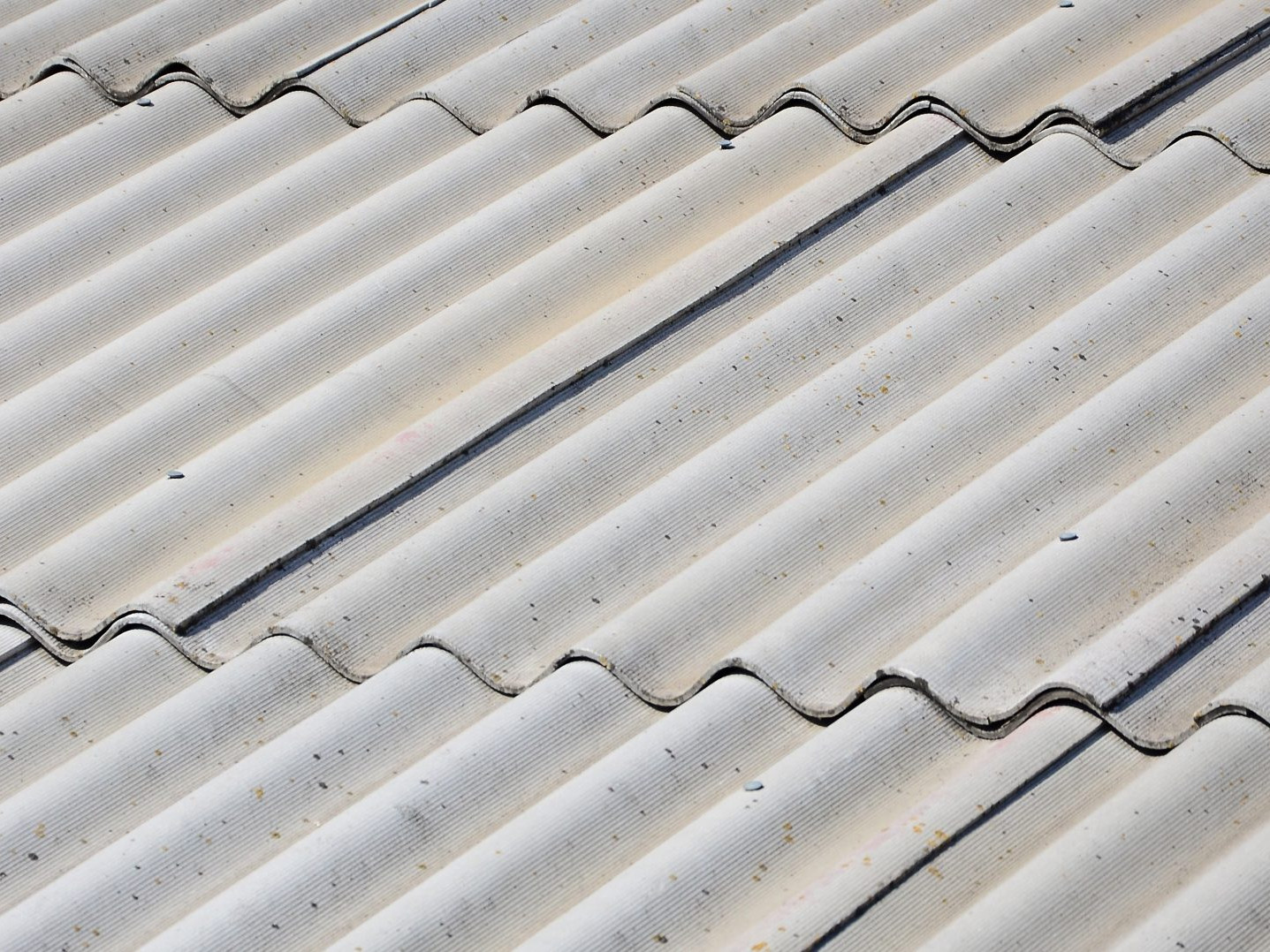 A fragment of a gray slate roof of an old sample made of asbestos material