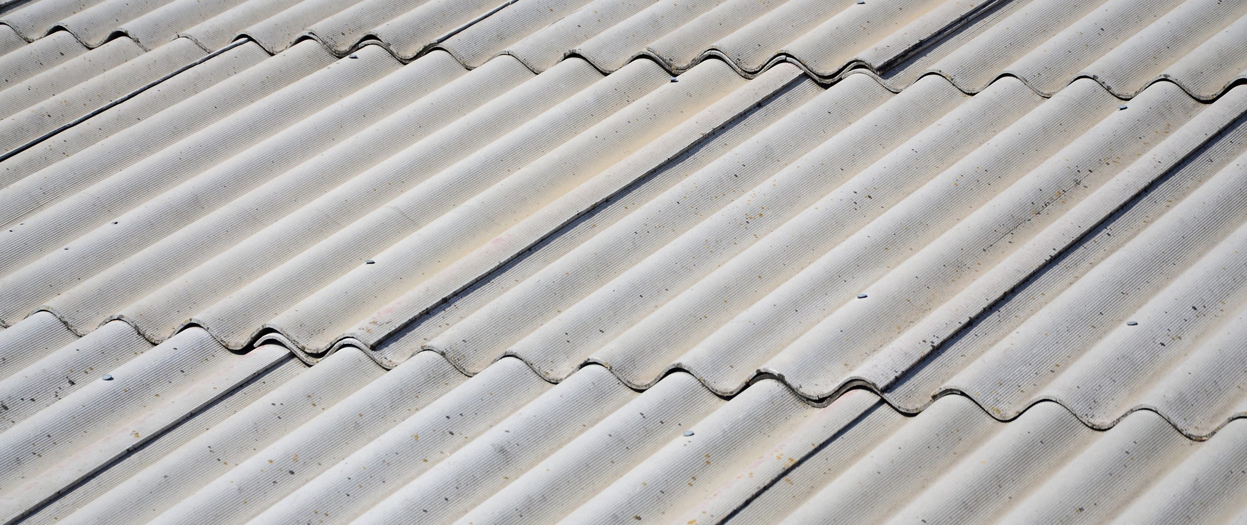 A fragment of a gray slate roof of an old sample made of asbestos material