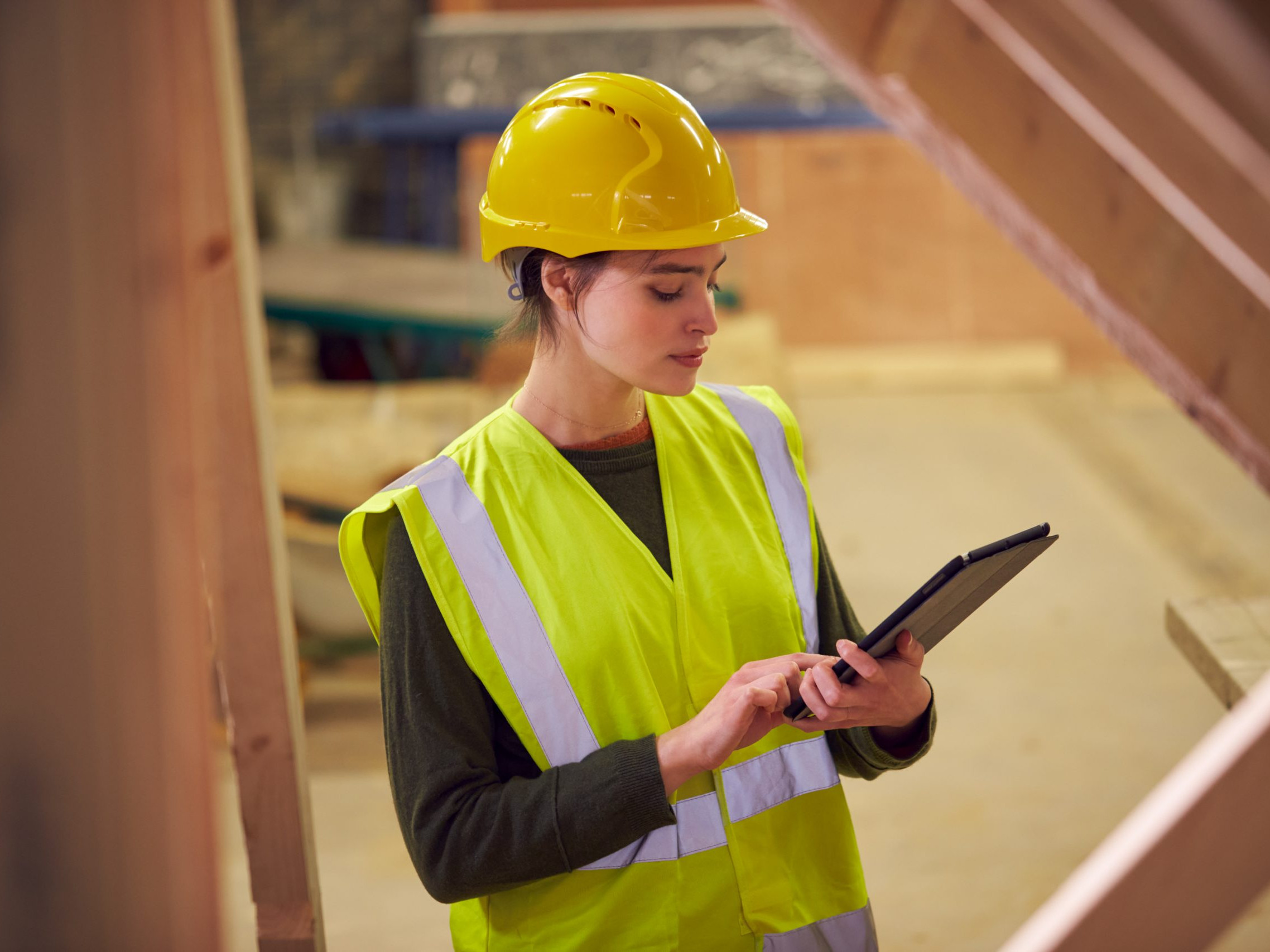 Female Safety Inspector With Digital Tablet At Construction Site