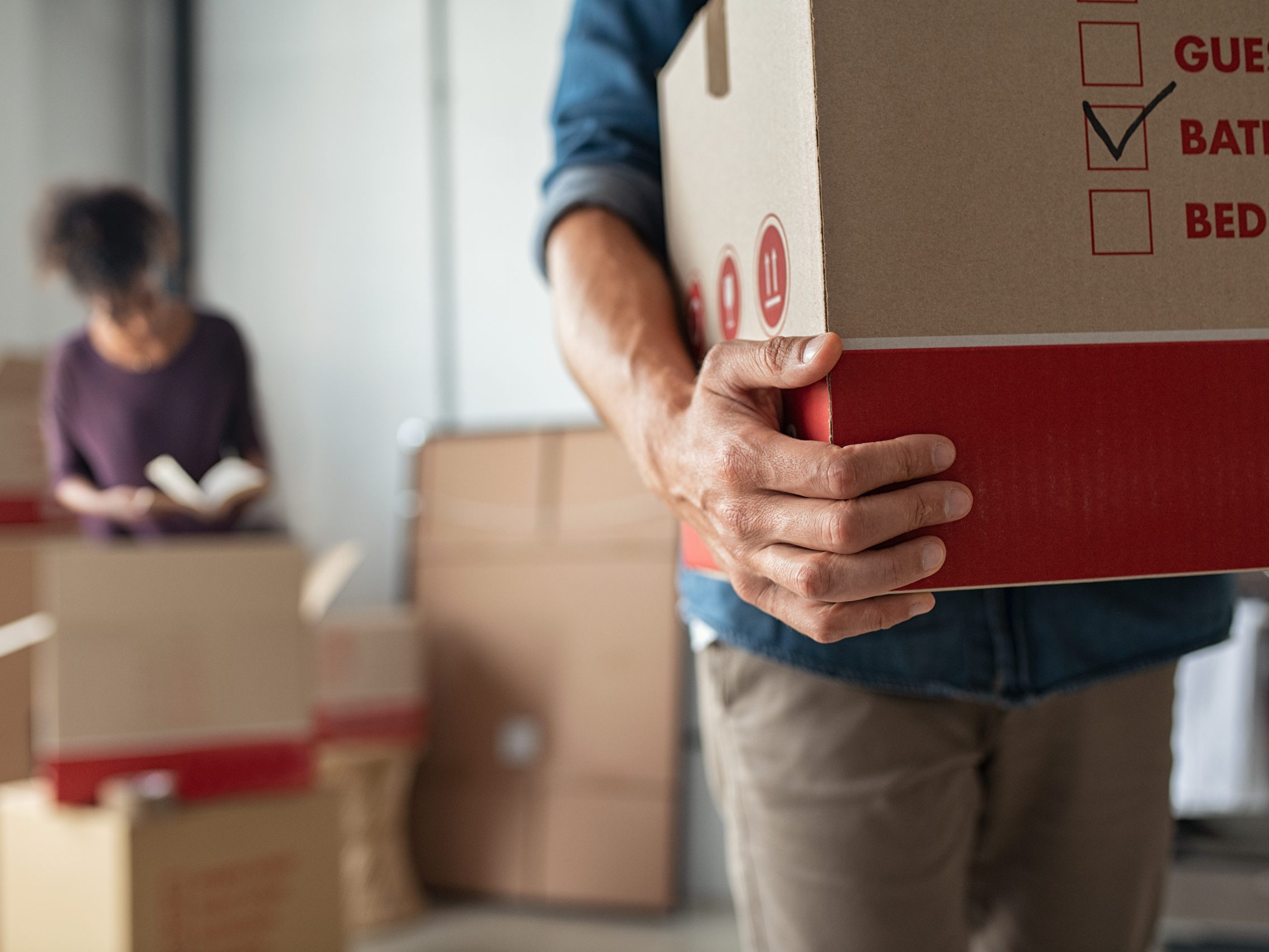Hands holding cardboard box during relocation