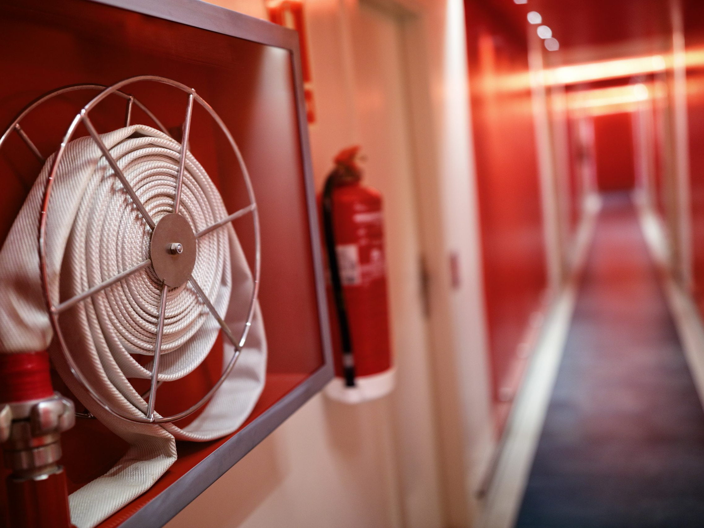 Fire extinguisher and hose reel in hotel corridor